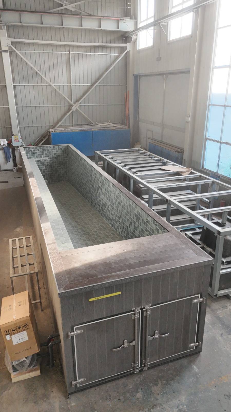 30ft tiled pool configuration with grey WPC exterior and front equipment doors in the factory
