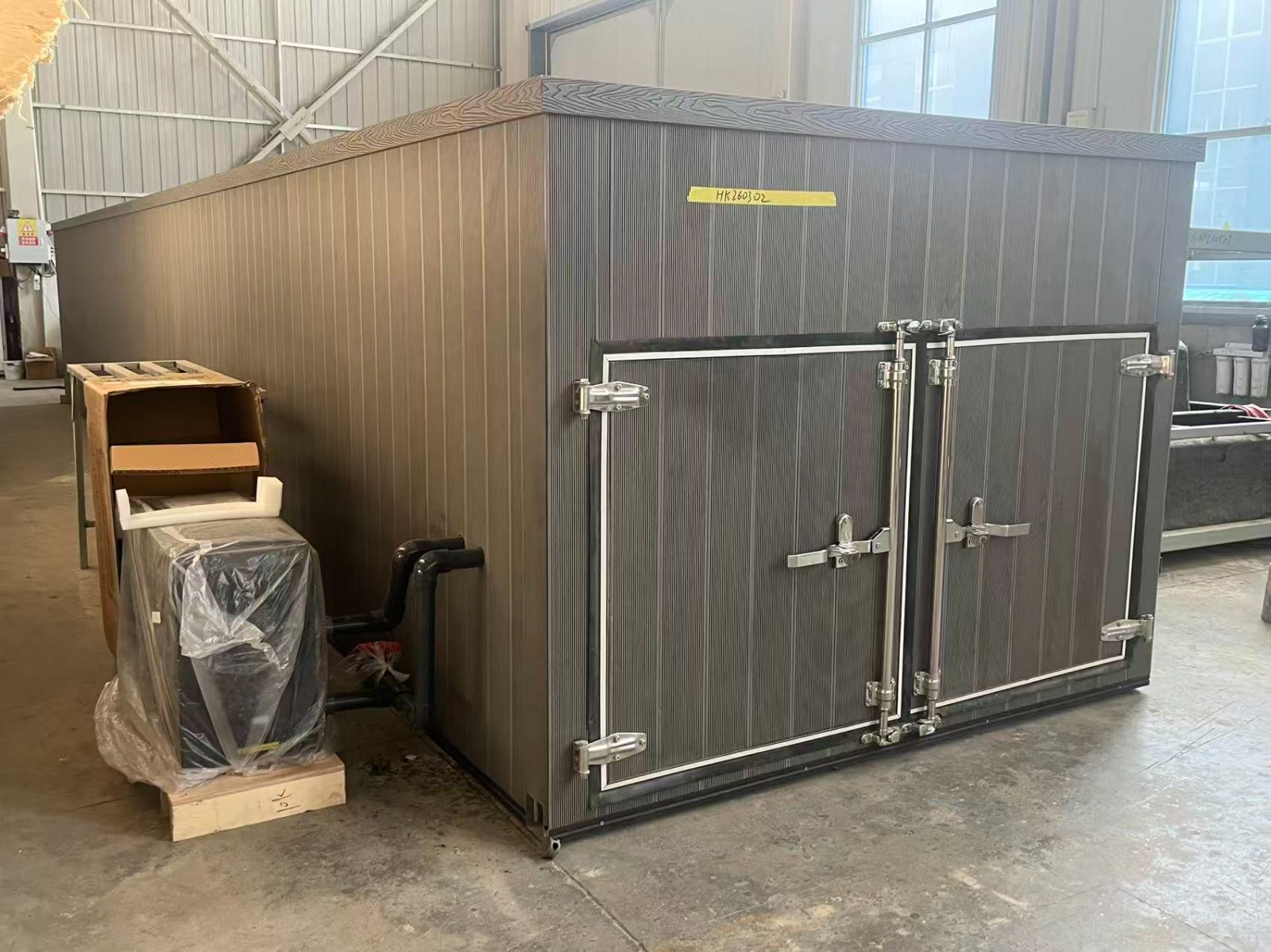 Tiled pool equipment-compartment doors and WPC exterior — factory photograph